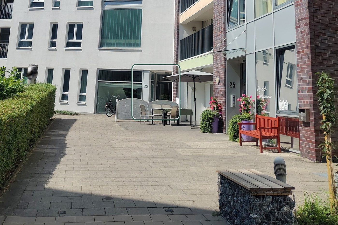 Blick in den Innenhof am Pottkamp: links das helle Gebäude mit der Hausnummer 23, der Praxiseingang ist grün markiert; rechts das Backsteingebäude mit der Nummer 25.